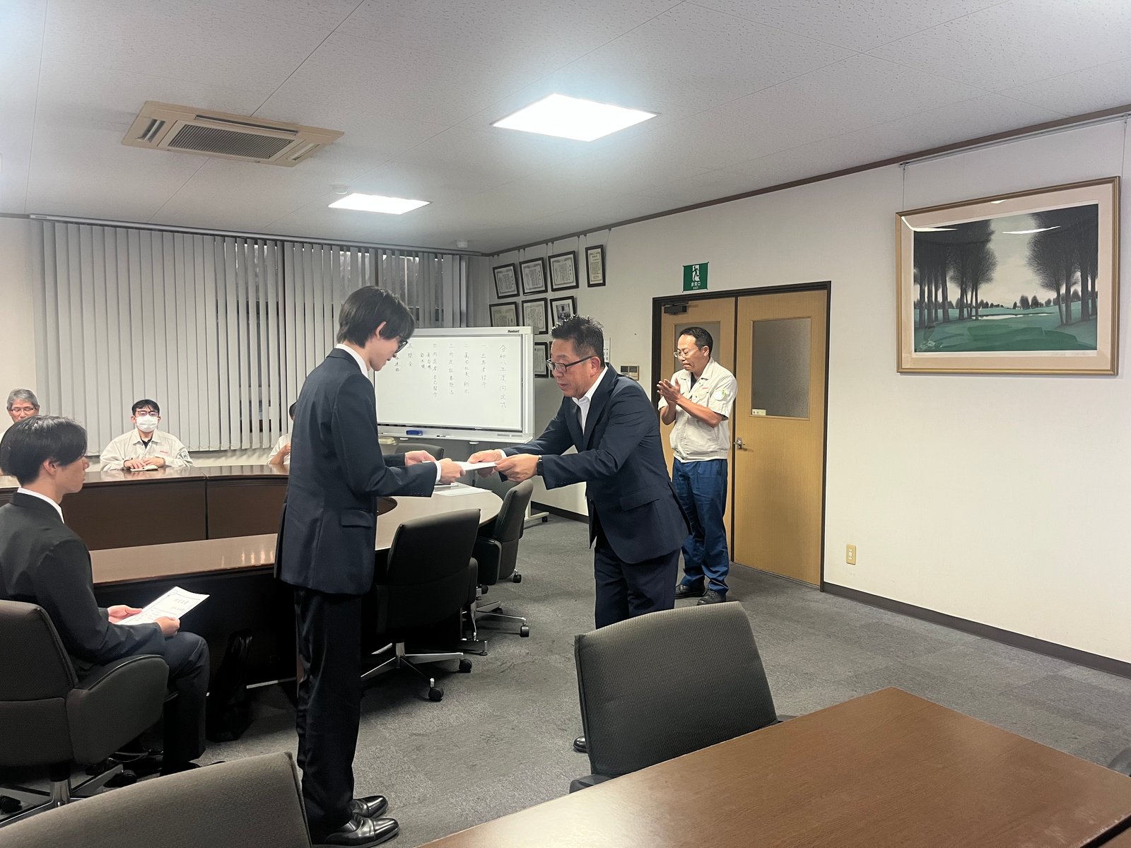内定式で内定者に内定通知書を手渡す様子